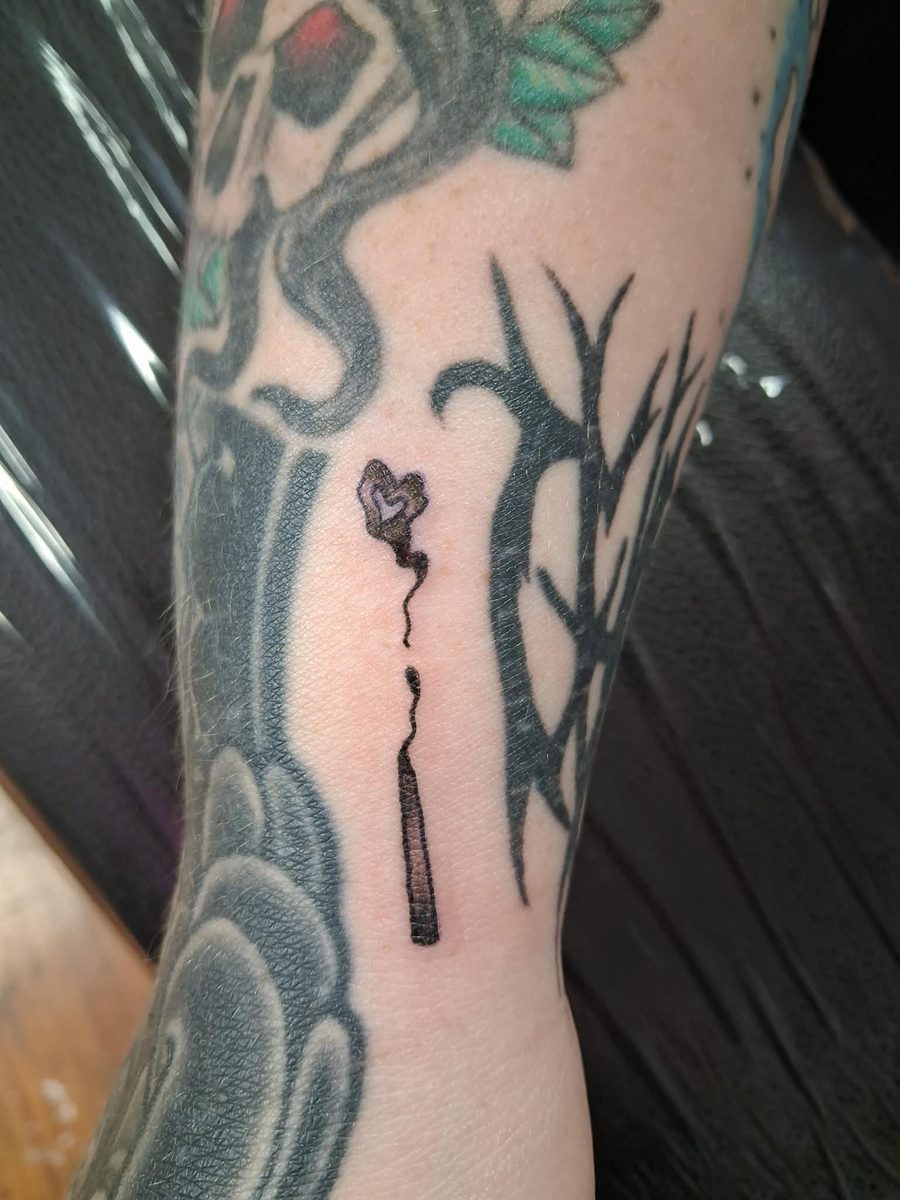 Fine line burnt-out match with smoke curling into a small heart, on an inner arm